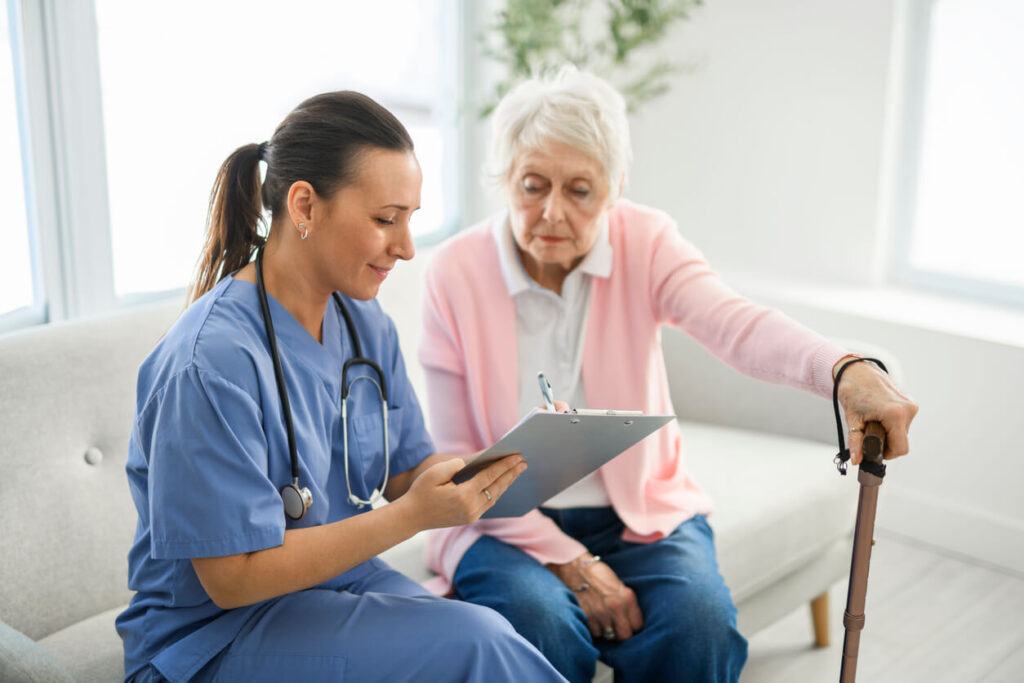 A portrait of a young nurse with a senior patient at home during a consultation