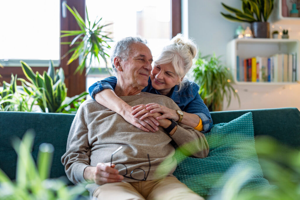 Senior-Living Portrait of a happy senior couple sitting on sofa at home